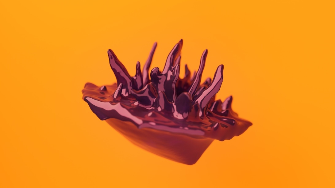 An artistic chocolate sculpture with spiky, crystalline formations against an orange background.